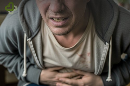 Мужчина держится за живот от боли